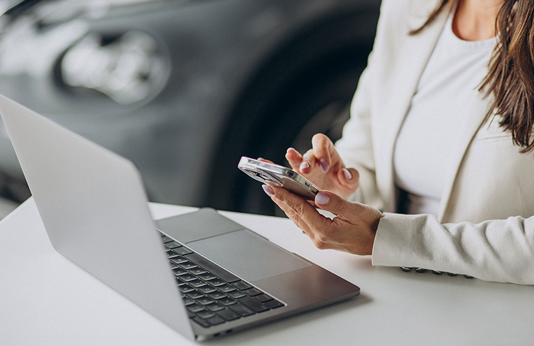 girl-on-phone-at-laptop-on-table.