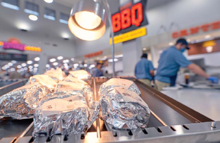 foil-wrapped-food-with-bbq-sign-in-background.