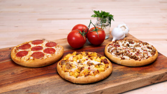 three-small-pizzas-on-wooden-board-with-tomatoes.