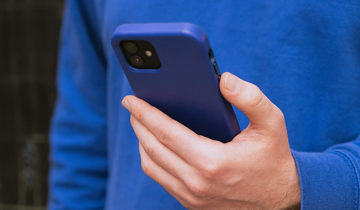 hand-holding-phone-blue-shirt.
